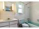 Retro bathroom with aqua colored sink, bathtub, toilet, and white tiled walls and flooring at 2938 Wolfensberger Rd, Sedalia, CO 80135