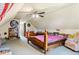 Attic bedroom with sloped ceilings, wood frame bed, ceiling fan, bookcase and natural light at 2938 Wolfensberger Rd, Sedalia, CO 80135