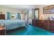 Comfortable bedroom features bright, natural lighting, cozy blue carpet and vintage wooden dresser at 2938 Wolfensberger Rd, Sedalia, CO 80135