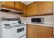 Functional kitchen with wood cabinets, vintage stove, and modern microwave at 2938 Wolfensberger Rd, Sedalia, CO 80135