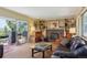 Inviting living room featuring a brick fireplace, built-in shelving, and outdoor access at 2938 Wolfensberger Rd, Sedalia, CO 80135