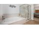 Bright bathroom featuring a soaking tub and glass enclosed shower with bench at 6617 S Forest Way # E, Centennial, CO 80121