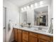 Double sink bathroom with wood cabinets, granite counters, and modern lighting at 6617 S Forest Way # E, Centennial, CO 80121