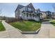 Inviting two-story home with a cozy front porch, complemented by a green lawn and tree at 3534 N Meadows Dr, Castle Rock, CO 80109