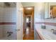 Bright bathroom featuring white tile walls, a retro pink accent stripe, and a shower area at 4530 S Inca St, Englewood, CO 80110