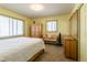 Comfortable bedroom with warm-toned walls, plush carpet, natural light, and rustic wood furnishings at 4530 S Inca St, Englewood, CO 80110