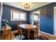 Dining room with hardwood floors, blue walls, and a wood table set for four at 4530 S Inca St, Englewood, CO 80110