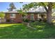 Charming brick home featuring a manicured front lawn, attractive landscaping, and mature trees at 4530 S Inca St, Englewood, CO 80110