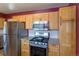 Kitchen featuring stainless steel appliances, natural wood cabinets, and tile backsplash at 4530 S Inca St, Englewood, CO 80110