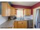 Kitchen with stainless steel appliances, natural wood cabinets, and stone countertops at 4530 S Inca St, Englewood, CO 80110