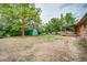 Spacious backyard with a storage shed, wooden deck, and mature trees providing ample shade at 363 Lima St, Aurora, CO 80010