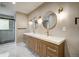 Modern bathroom with double vanity, quartz countertops, round mirrors, and a glass-enclosed shower at 363 Lima St, Aurora, CO 80010