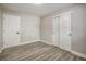 Bedroom featuring wood-look floors, closet doors, and a white door with black hardware at 363 Lima St, Aurora, CO 80010