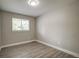 Bright bedroom featuring wood-look floors, a window with blinds, and a modern ceiling light at 363 Lima St, Aurora, CO 80010