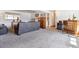 Spacious basement area with carpet, grey sofa and a wooden cabinet at 9379 W Burgundy Ave, Littleton, CO 80123