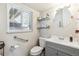 Cozy bathroom featuring a gray vanity, round mirror, and a window providing natural light at 9379 W Burgundy Ave, Littleton, CO 80123