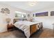 Comfortable bedroom with unique wood and metal frame bed, neutral decor, and a window view at 9379 W Burgundy Ave, Littleton, CO 80123