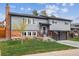 Beautiful two-story home showcasing gray siding, a brick facade, and a lush green lawn at 9379 W Burgundy Ave, Littleton, CO 80123