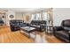Cozy living room featuring hardwood floors, leather furniture, and natural light from large windows at 9379 W Burgundy Ave, Littleton, CO 80123