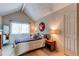 Cozy bedroom with vaulted ceiling, large window, and wood nightstand at 8855 Green Meadows Dr, Highlands Ranch, CO 80126