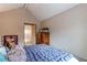 Charming bedroom with vaulted ceiling and wood dresser at 8855 Green Meadows Dr, Highlands Ranch, CO 80126