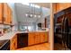 Modern kitchen with wood cabinets, black appliances and hardwood floors at 8855 Green Meadows Dr, Highlands Ranch, CO 80126