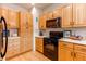 Kitchen with wood cabinets, black appliances and light countertops at 8855 Green Meadows Dr, Highlands Ranch, CO 80126
