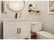 Cozy bathroom featuring white vanity, round mirror, and decorative shelf with plant at 1331 Alpine St, Longmont, CO 80504