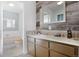 Bathroom featuring tile countertop, modern mirror, and wood-paneled accent wall at 1331 Alpine St, Longmont, CO 80504