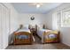 Bright bedroom featuring twin beds, carpet, white walls, blue ceiling, and large window at 1331 Alpine St, Longmont, CO 80504