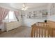 Bright Bedroom featuring wood crib, large shelving unit, and pink curtains at 1331 Alpine St, Longmont, CO 80504