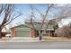 Two-story home with a green garage door, stone accents, and mature trees at 1331 Alpine St, Longmont, CO 80504