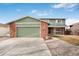 Charming two-story home features a green garage door and beautiful stone detailing at 1331 Alpine St, Longmont, CO 80504