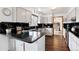 Stylish kitchen with black countertops, white cabinetry, and a view into the dining room at 1331 Alpine St, Longmont, CO 80504