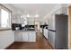 Modern kitchen with white cabinets, black countertops, stainless steel appliances, and hardwood floors at 1331 Alpine St, Longmont, CO 80504