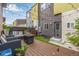 Cozy backyard with wooden deck, stylish seating, modern fence, and a gas fire pit for outdoor relaxation at 2824 W Parkside Pl, Denver, CO 80221