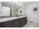 Bathroom featuring double sinks with wood cabinets, a large mirror, and a tiled shower at 2824 W Parkside Pl, Denver, CO 80221