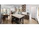 Open-concept kitchen features a center island, stainless appliances, and wood floors with a dining area at 2824 W Parkside Pl, Denver, CO 80221