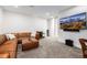 A spacious living room with carpet, a large sectional sofa, and a TV at 2824 W Parkside Pl, Denver, CO 80221