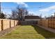 Large backyard enclosed by a wood fence and featuring a neatly trimmed lawn at 4650 W 9Th Ave, Denver, CO 80204