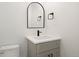 Modern bathroom features a stylish vanity with a rounded mirror, sleek black fixtures, and a clean, minimalist design at 4650 W 9Th Ave, Denver, CO 80204