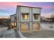 Modern two-story home with a two-car garage and manicured front yard during a colorful sunset at 4650 W 9Th Ave, Denver, CO 80204