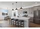 Modern kitchen features grey cabinets, stainless steel appliances, and a large island with bar stool seating at 4650 W 9Th Ave, Denver, CO 80204