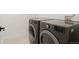 Modern laundry room featuring an energy-efficient washer and dryer set with tile flooring at 4650 W 9Th Ave, Denver, CO 80204