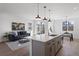 Open living area with grey cabinets, island with sink, sofa, area rug, and dining table at 4650 W 9Th Ave, Denver, CO 80204