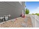 This backyard shows a stone walkway and chairs in a gravel area surrounded by a white picket fence at 18645 E 54Th Pl, Denver, CO 80249