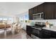 Open kitchen with black cabinets, stainless appliances, and a dining area with scenic views at 18645 E 54Th Pl, Denver, CO 80249