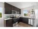 Stylish kitchen with stainless steel appliances, dark cabinets, and ample counter space at 18645 E 54Th Pl, Denver, CO 80249