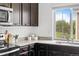 Modern kitchen with dark wood cabinets, granite countertops, stainless steel sink, and outside view at 18645 E 54Th Pl, Denver, CO 80249