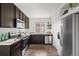 Modern kitchen features stainless steel appliances, granite countertops, and dark wood cabinetry at 18645 E 54Th Pl, Denver, CO 80249